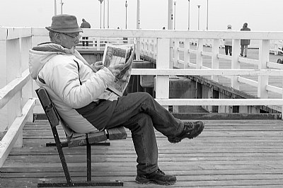 An Old Man Reading A Newspaper