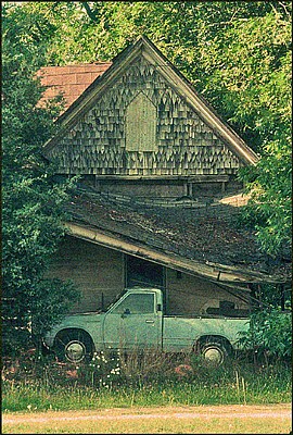   A Decaying House ready to fall on 70's Truck