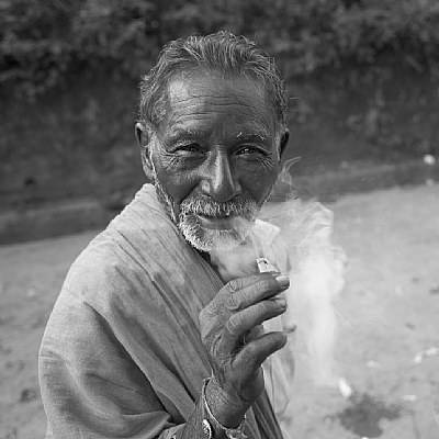 elderly man smoking a bidi.